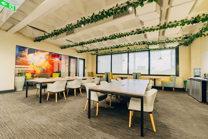Open coworking floor with tables and hanging vines