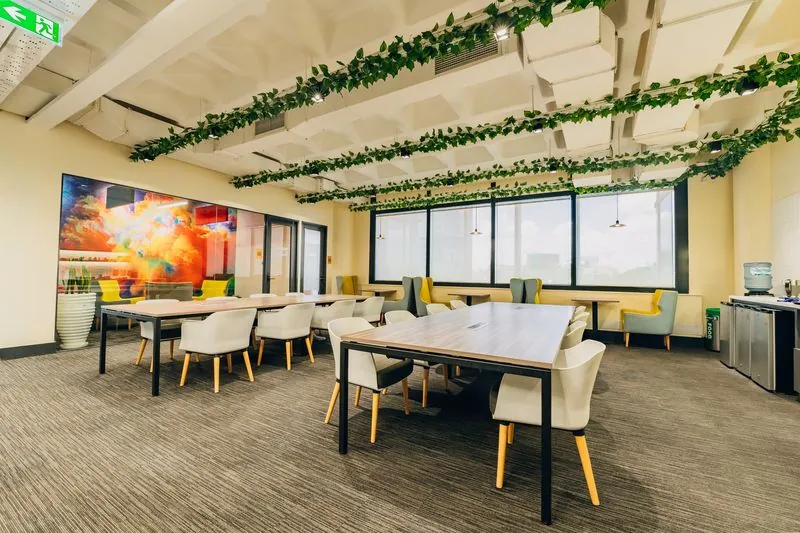 Open coworking floor with tables and hanging vines
