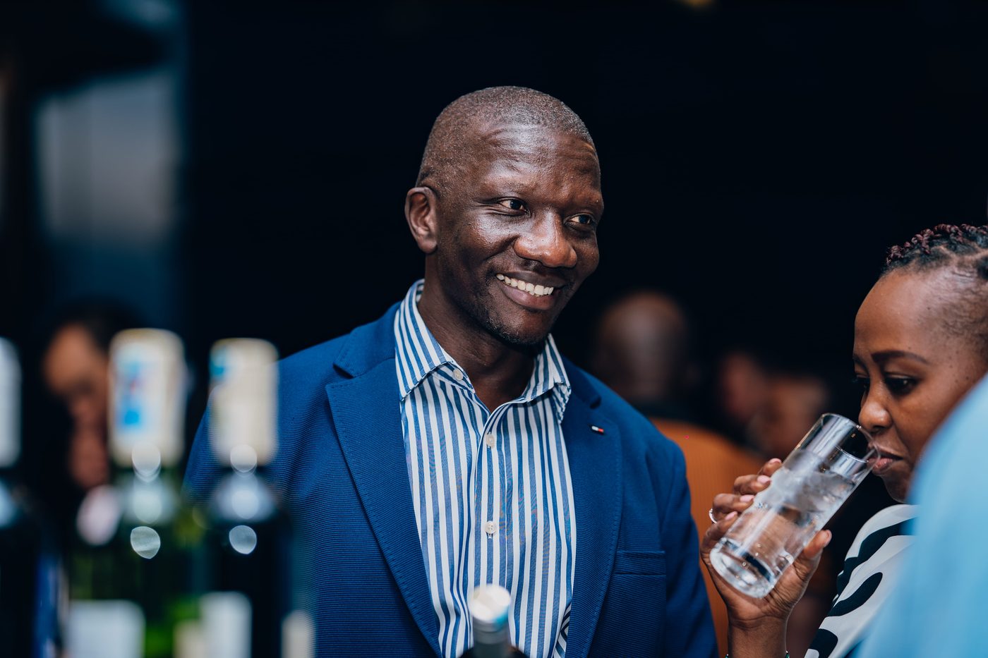 Man in striped shirt smiling at evening corporate event