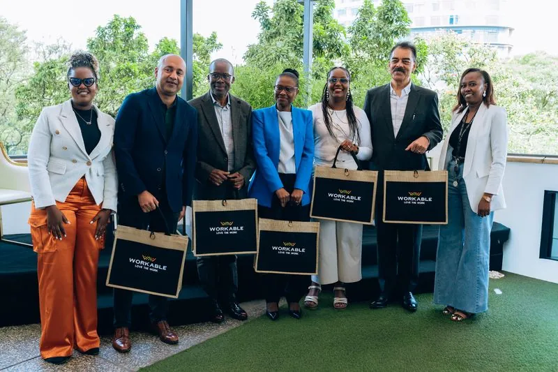 Panellists and hosts posing together holding branded gift bags