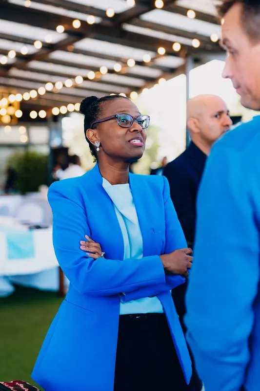 Guest in a bright blue blazer listening on a rooftop