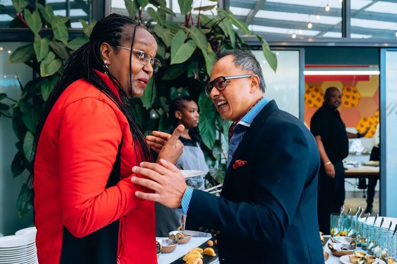 Two guests greeting each other warmly at the breakfast buffet