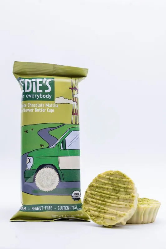Edie's matcha white chocolate cups pack standing beside two cups