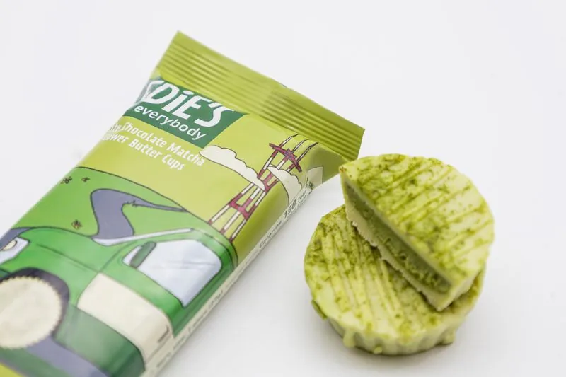 Edie's matcha pack lying flat beside a split matcha cup