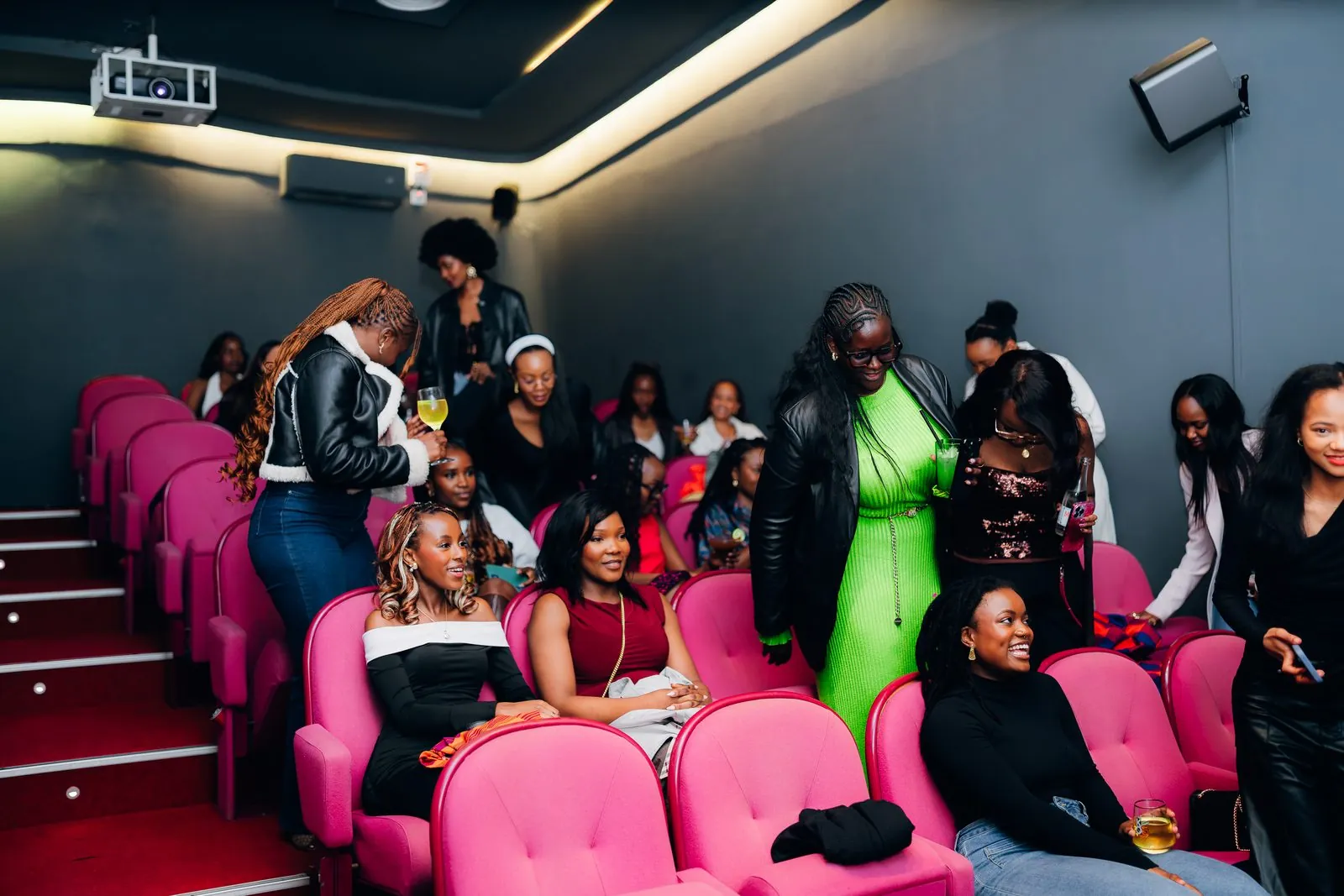 Audience settling into pink cinema seats