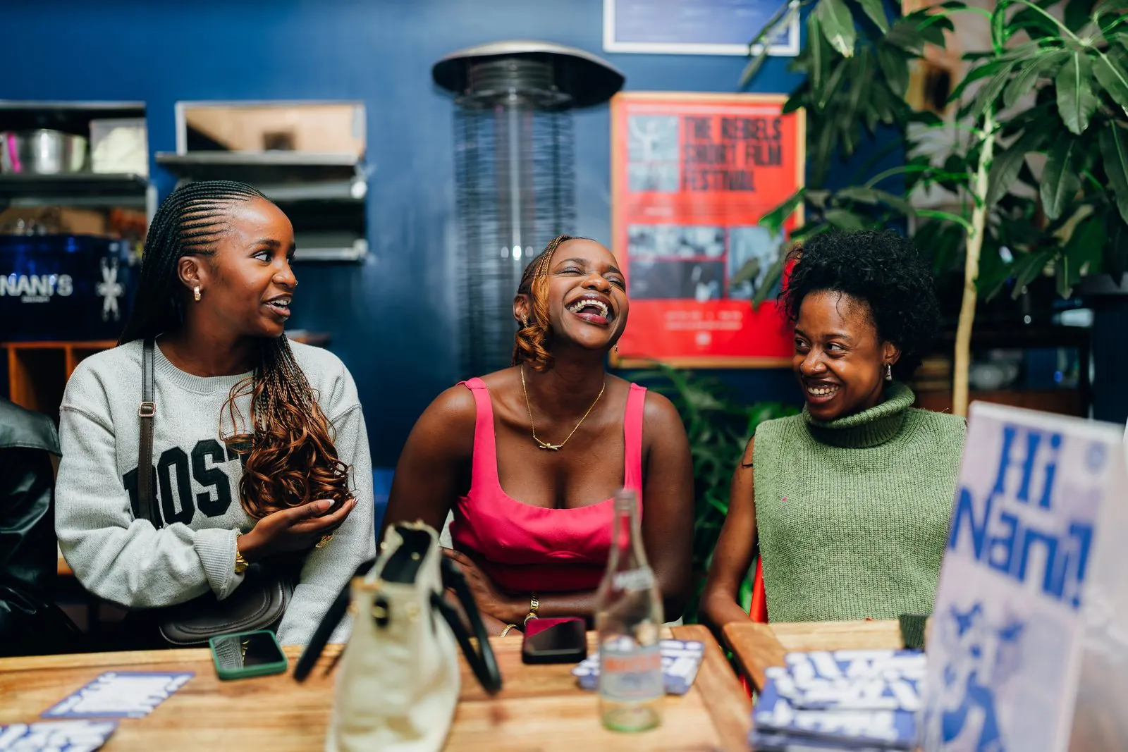 Three friends laughing at a dinner table