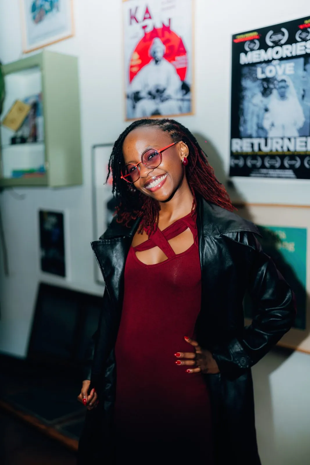 Guest posing in a leather jacket in front of film posters