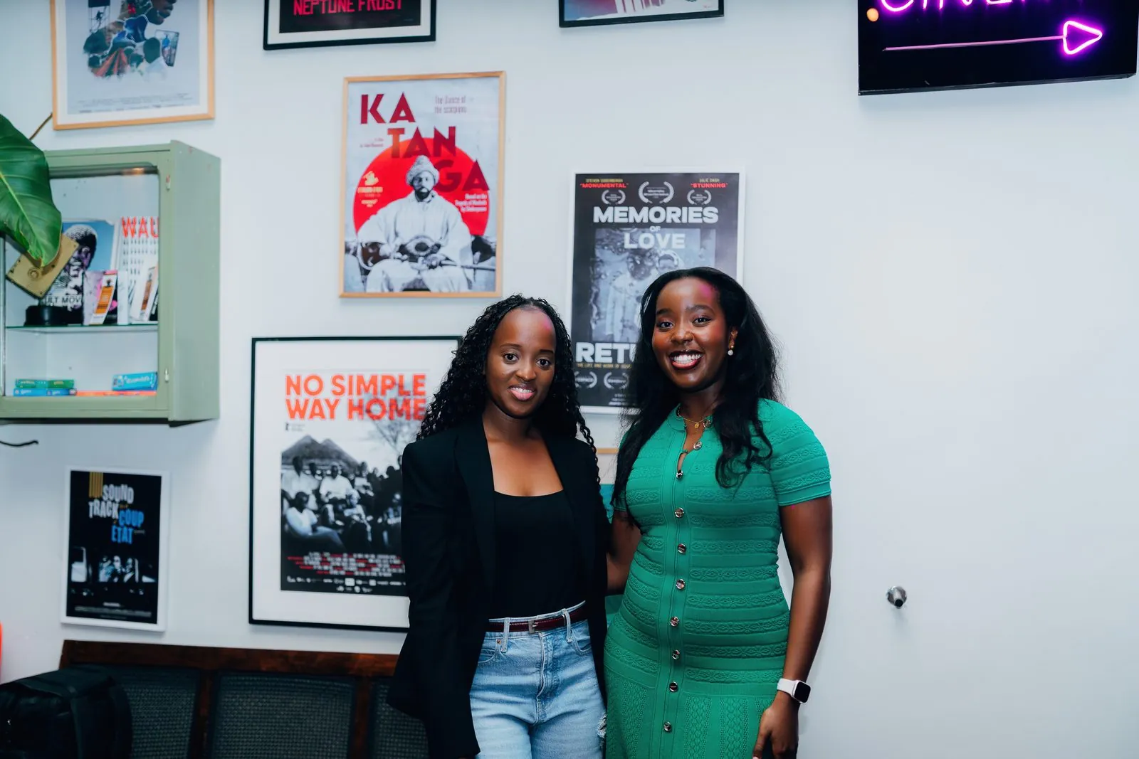 Two guests posing in front of framed film posters