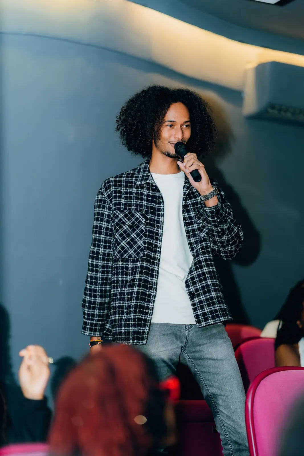 Guest in a plaid shirt speaking into a microphone