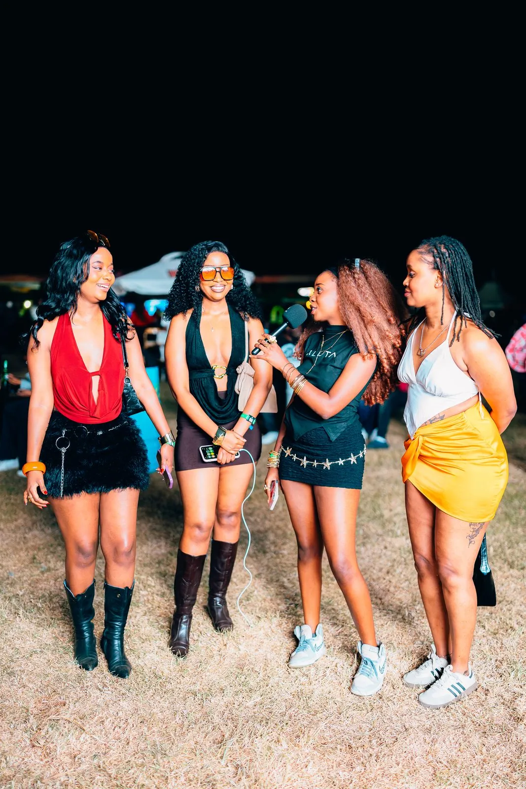 Four friends walking across the festival grounds at night