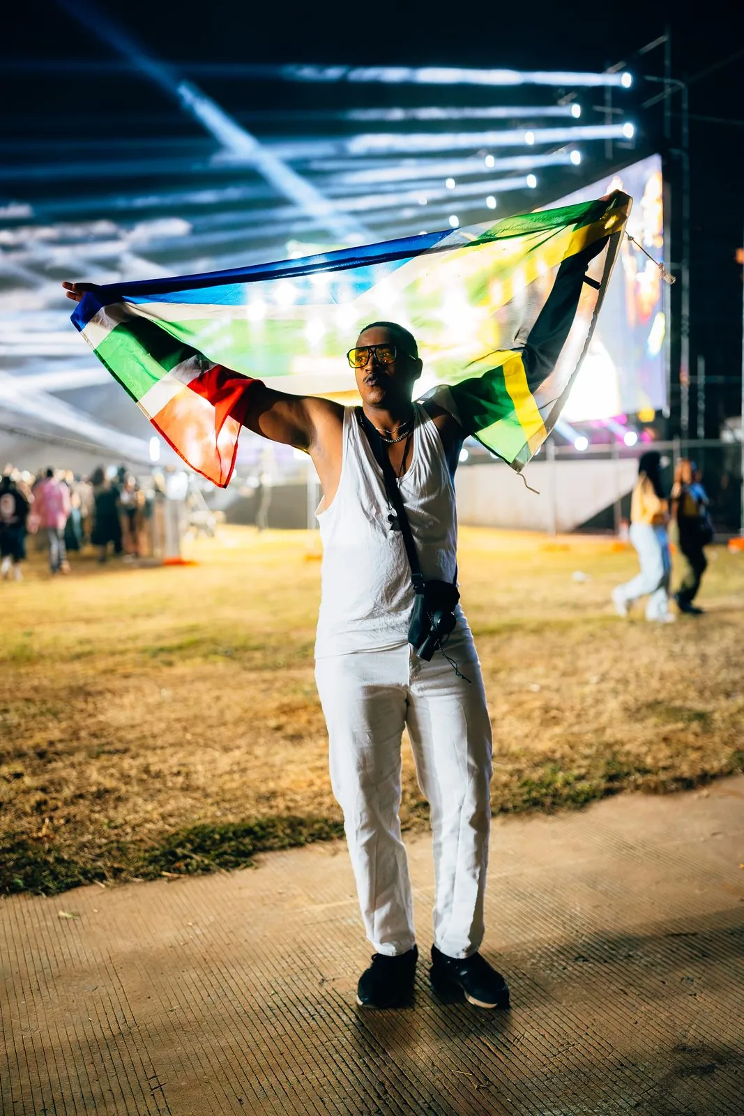 Man holding a flag overhead on the festival grounds