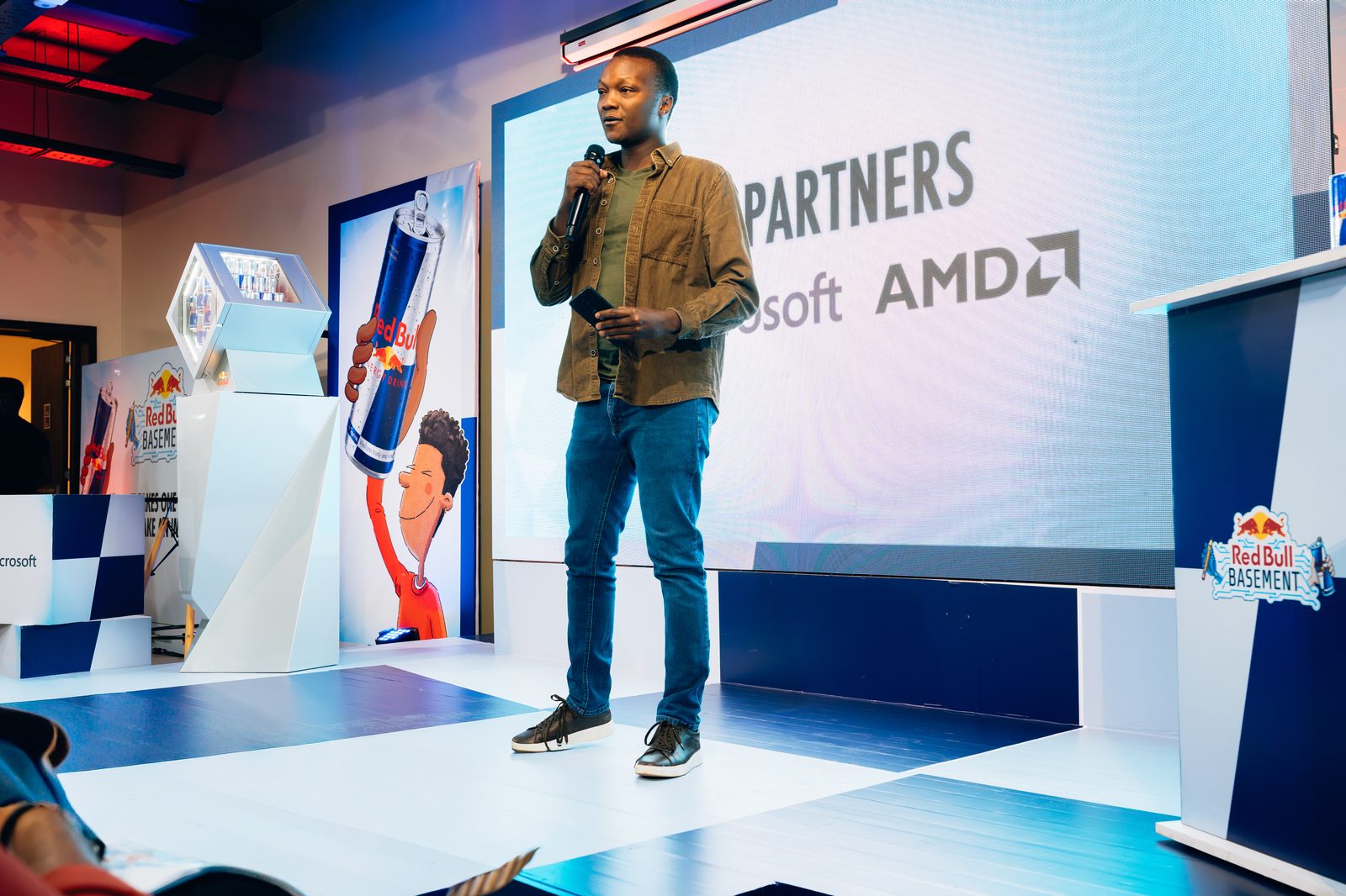 Speaker on stage with Microsoft & AMD partners slide