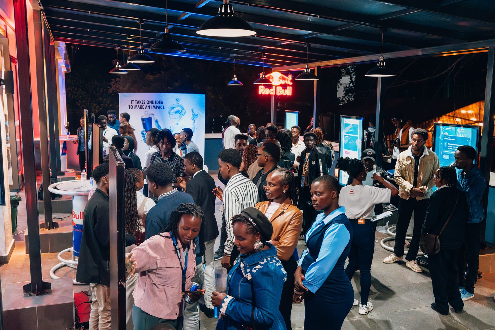 Crowd at the activation booths under neon Red Bull signage