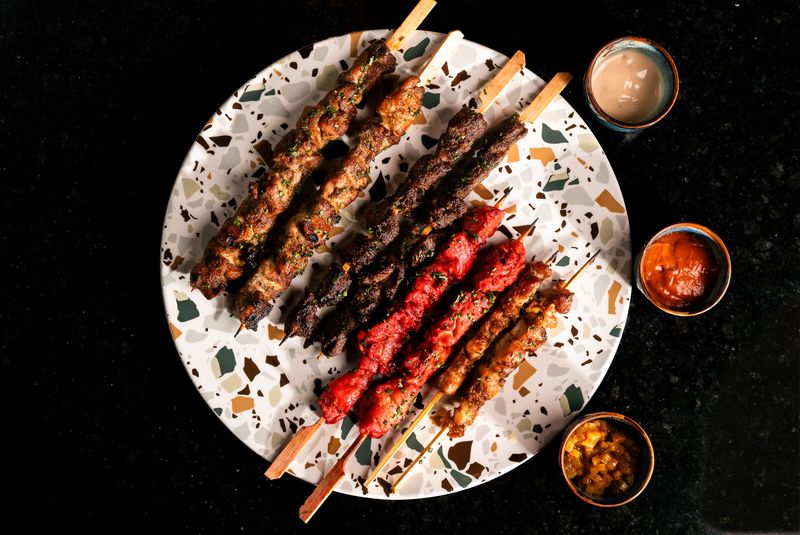 Mixed grilled skewers on terrazzo plate