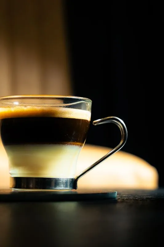 Layered espresso in a glass cup in hard light