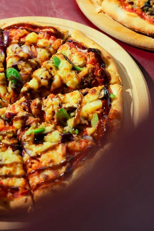 Close crop of a vegetable pizza on a wooden board