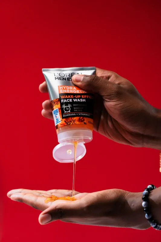 Face wash gel poured into an open palm on red