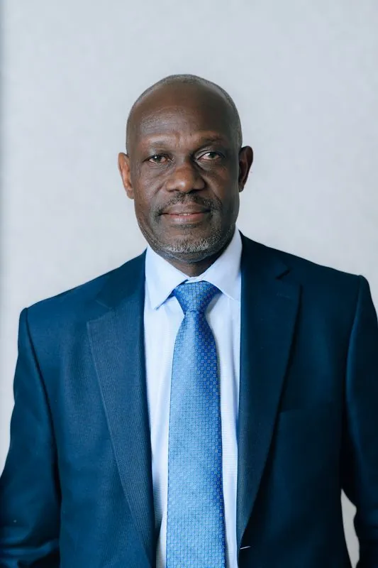 Corporate headshot against a pale grey backdrop