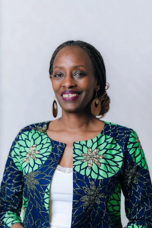 Corporate headshot in a printed jacket against grey