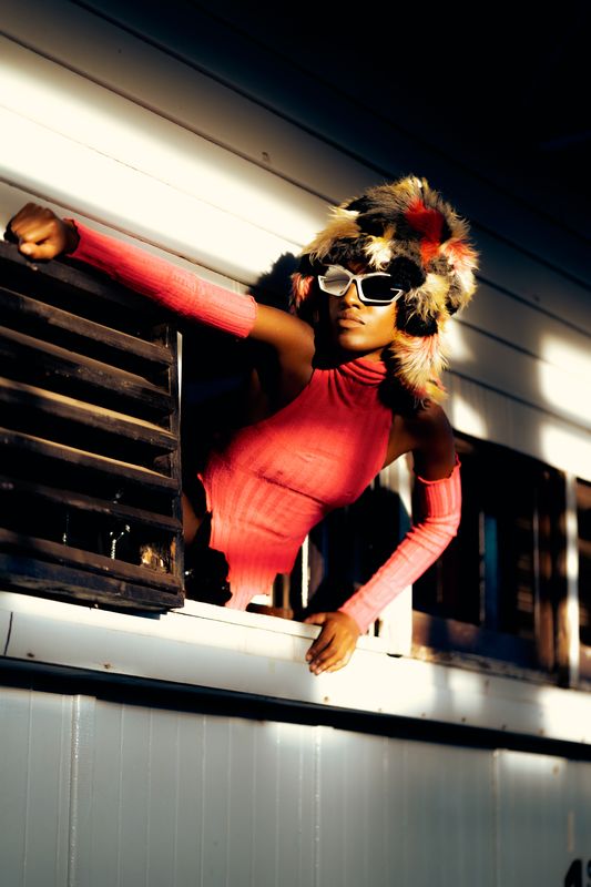 Bold fashion portrait, golden hour, rail yard