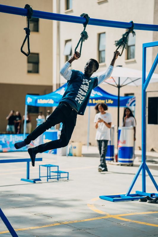 Player swinging between rope rings — feet off the ground, in motion