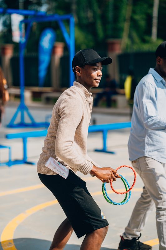 Young player walking with rope rings between game stations
