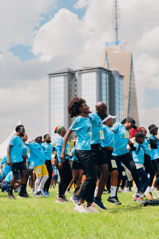 Runners warming up before the Wings for Life World Run with Britam Tower in the background